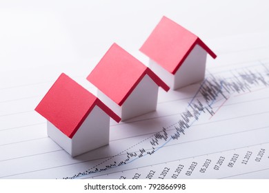 High Angle View Of House Models On Financial Chart At Office Desk