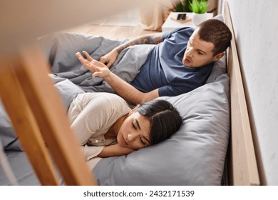 high angle view of irritated man quarreling at upset asian wife on bed at home, divorce concept - Powered by Shutterstock