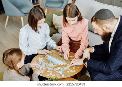 High Angle View At Jewish Family Playing Puzzle Game Together At Home