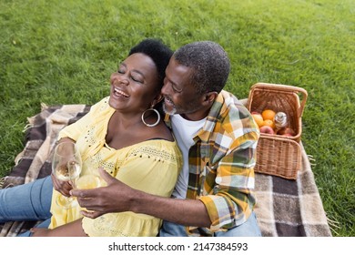 High Angle View Of Joyful And Senior African American Couple Clinking Glasses Of Wine During Picnic In Park