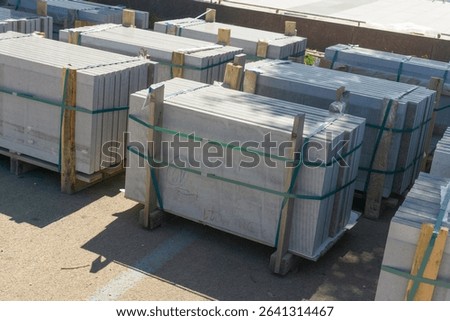 high angle view of large grey concrete slabs stacked on wooden pallets, concept of building materials, construction industry, prefabrication. High quality photo