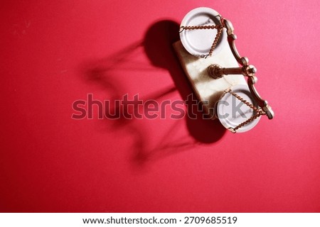 high angle view of libra scale against red background                     