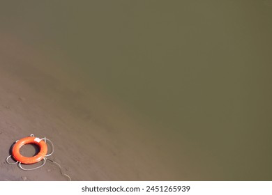 High angle view of a life belt on the edge of a river. Concept of safety and prevention. - Powered by Shutterstock