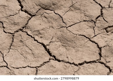 High angle view of light brown baked earth with cracks