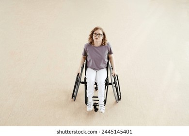 High angle view long shot of young Caucasian female wheelchair dancer with disability in spacious room - Powered by Shutterstock