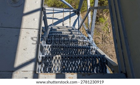 High angle view looking down steep metal grating stairs of observation tower