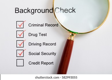 High Angle View Of Magnifying Glass Over Background Check Form