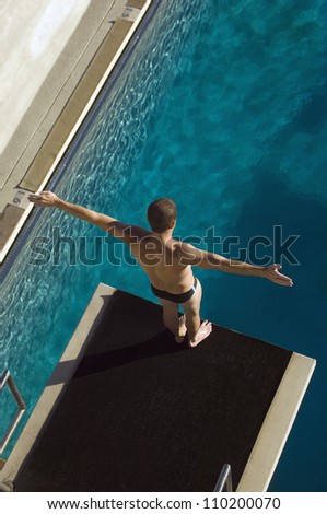 High angle view of a male diver ready to dive into the pool