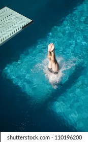 High Angle View Of A Male Diver's Legs Diving Into The Pool