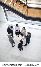 High Angle View Of Male And Female Business Executives Discussing In Office Lobby