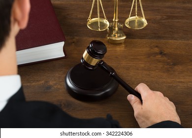 High angle view of male judge hitting mallet at desk in courtroom - Powered by Shutterstock