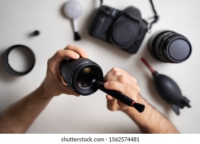 High Angle View Of Man Cleaning Camera Lens Element