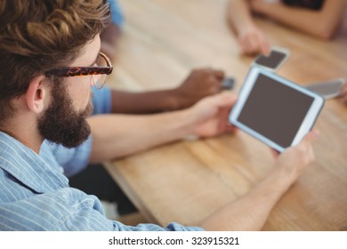 High Angle View Of Man Holding Digital Tablet At Desk