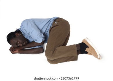 high angle view of a man lying on the floor in the fetal position