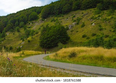 High angle view of a man mountain biking along a street. Mountains on the background. Copy space. 