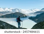 High angle view of man overlooking Glacier Grey and Lago Grey surrounded by snow covered mountains of the Paine Massif along W-trek hiking route in Torres del Paine National Park, Patagonia, Chile