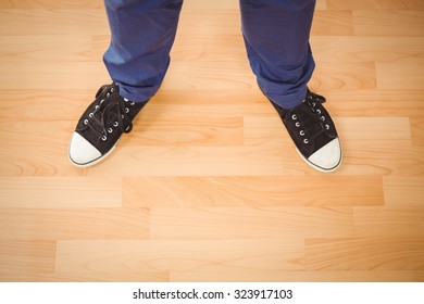 High angle view of man wearing canvas shoes standing on hardwood floor
