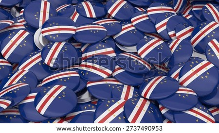 A high angle view of many circular pins showing the Cabo Verdean flag colors with gold stars