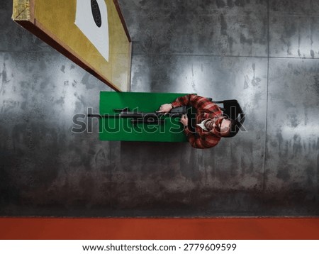 High Angle View of a Marksman with Precision Sniper Rifle Practicing Long Range Shooting at Indoor Range Table.