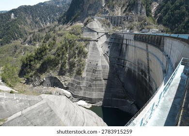 High angle view of the massive arch structure at Kurobe Dam.