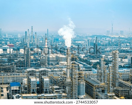 High angle view of a massive oil refinery and chemical plant with distillation towers and industrial equipment.