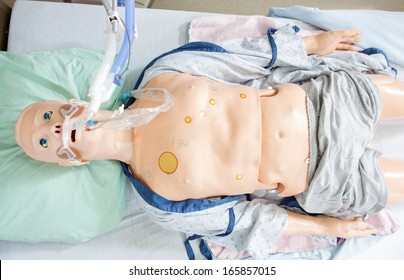 High angle view of medical dummy with endotracheal tube lying on hospital bed