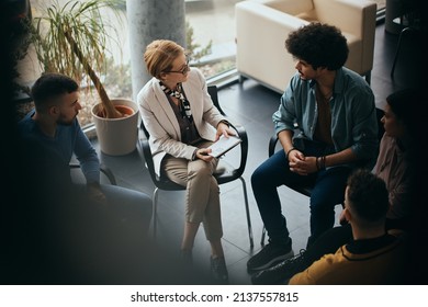 High Angle View Of Mental Health Professional Talking To Participants Of Group Therapy At Community Center.