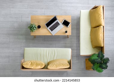 High Angle View Of Modern Coworking Space. Coffee Cup, Flower Pot, Laptop And And Tablet Computer Are On Wooden Table.