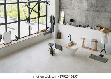 High Angle View Of Modern Interior At Contemporary Bathroom, Folded Clean Towels On Wooden Shelf At Empty Bath Near Cotton Bathrobe And House Decor With Copy Space On Concrete Floor