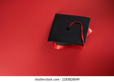 High Angle View Of Mortar Board Against Red Background