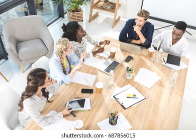 High Angle View Of Multicultural Group Of Business People Discussing Work In Office