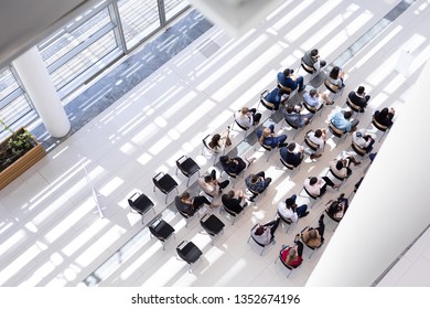 High Angle View Of Multi-ethnic Group Of Business People Sitting On Chair In Lobby At Office