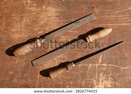 High angle view of multiple retro metal rasps with different timber handles.