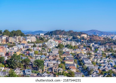 High Angle View Of The Neighborhood Near The Hills In San Francisco, CA. View Of Dense Houses And Streets With Trees Against The Mountains And Sky Background.