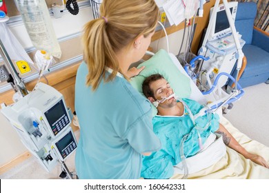 High angle view of nurse adjusting young patient's pillow in hospital room - Powered by Shutterstock