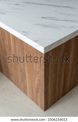 High angle view of oak table with a marble top showcases a modern design in a bright, minimalist room. Empty kitchen countertop, close up. Corner of white counter in apartment with scandinavian style