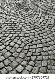 High angle view of an old cobblestone pavement pattern with a cross sign carved on a stone.