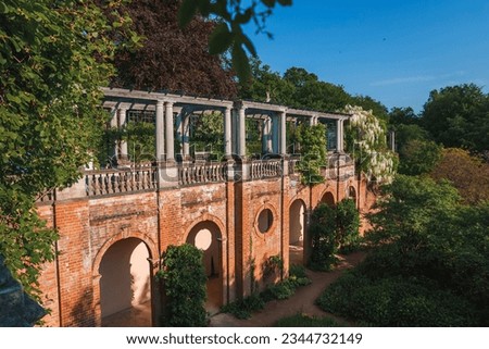 High angle view of old structure at The Hill Garden and Pergola. Wisteria plants growing on columns with blue sky in background. Beautiful view of park in Hampstead Heath during sunny day.