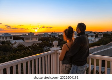 High angle view on colorful sunset paradise with young couple woman man watching looking at view on Gulf of Mexico in Seaside, Florida on rooftop terrace building house balcony - Powered by Shutterstock