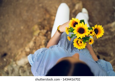 High angle view on young woman holding sunflowers waiting for her love