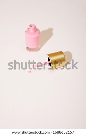 High angle view of opened bottle of pink nail polish on white background