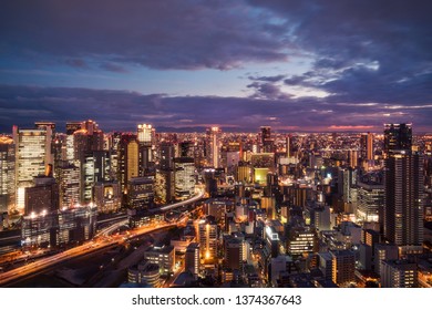 High Angle View Of Osaka City From The Top Of Umeda Sky Building In The Evening With Bright City Lights And Light Trails In The  Kansai Region, Japan.