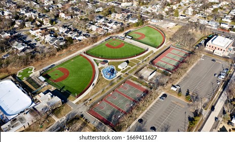 A High Angle View Over An Empty Grant Park With Basketball Courts, Tennis Courts & Three Colorful Baseball Fields. There Is Also A Hockey Rink. It Is A Sunny Day And There Are No People In Sight