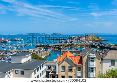 High angle view over Harbor of Saint Peter Port, Guernsey, Channel Islands, UK. The Islands of Herm and Sark are visible in the distance