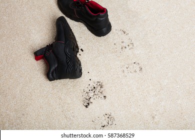 High Angle View Of A Pair Of Shoes With Mud Lying On Carpet Floor