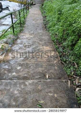 High angle view of patterned concrete stairs going down to a river in a green park.