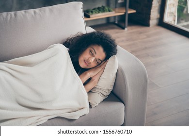 High Angle View Photo Of Beautiful Dark Skin Wavy Lady Holding Hands Under Head Eyes Closed Having Daydream Lying Comfy Couch Covered White Soft Blanket Living Room Indoors