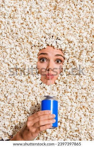 High angle view photo of girl arm hold soda drink can sip straw face buried in full with popcorn background