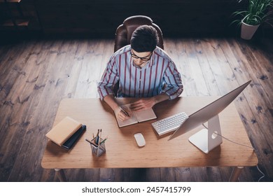 High angle view photo of young corporate man write notepad wear striped shirt modern office home indoors - Powered by Shutterstock