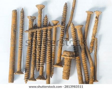 High angle view of a pile of old rusty nails and screws on a white background.
A collection of heavily rusted metal nails, screws, and bolts scattered on a plain white background, showing oxidized orange texture and industrial waste concept. Taken In Dau, Malang, East Java Indonesia, On July 19 2026